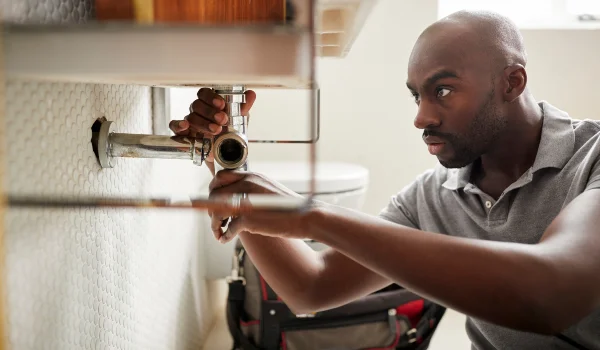 a male plumber fixing a bathroom faucet in Leander, TX - Leander, TX